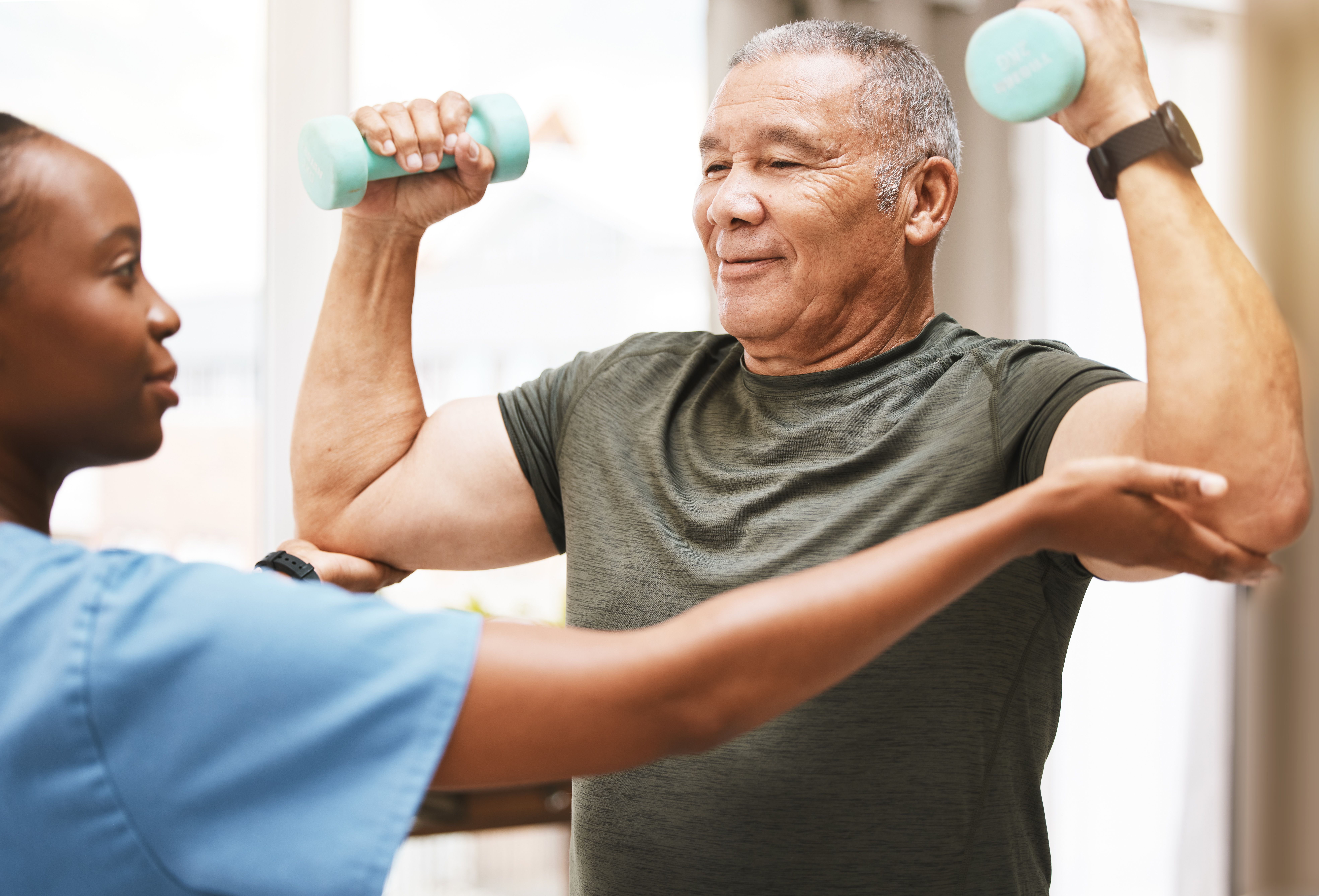 Man lifting weights with therapist